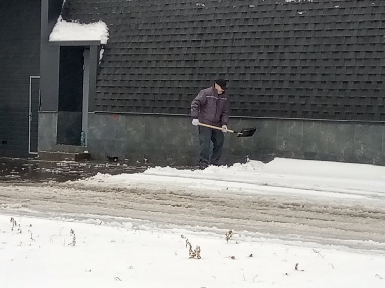 Біля магазинів та заправок сніг чистять їхні працівники